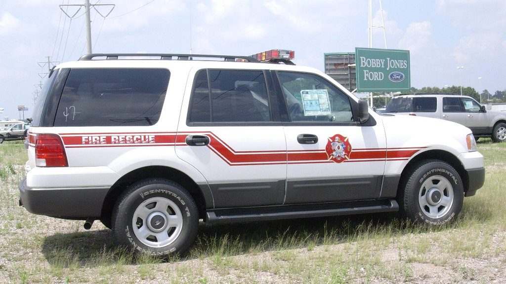 white fire rescue car parked in a field near bobby jones ford