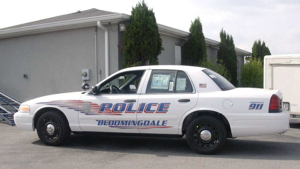white bloomingdale police car with blue and red line design