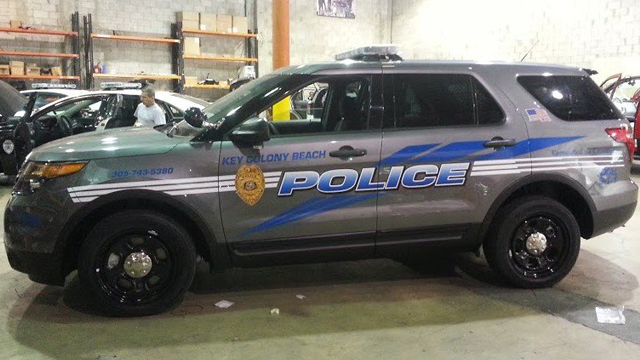 grey key colony police car with logo and blue line design