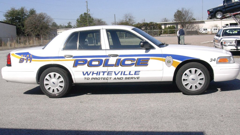 whiteville white police car with blue and yellow line desjgn